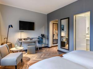 una camera d'albergo con letto, tavolo e sedia di Mercure Hotel Dortmund Centrum a Dortmund