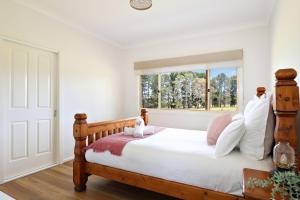 a bedroom with a bed with white sheets and a window at Fynns Run in Hartley