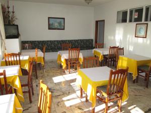 restauracja ze stołami, krzesłami i żółtymi stołami w obiekcie Pensao Residencial Vila Teresinha w Funchal