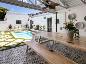 a patio with a wooden table and a pool at The Belmont in Franschhoek