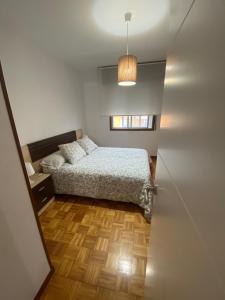 een kleine slaapkamer met een bed en een raam bij Céntrico, amplio y bonito apartamento en Cambados in Cambados
