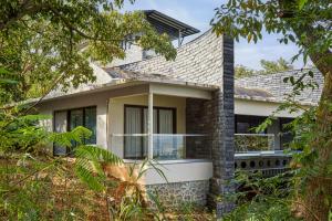 una casa con vistas a la parte delantera en SaffronStays Yahvi Waters by Kosha Villas, Pawna - pool villa with stunning lake view, en Lonavala