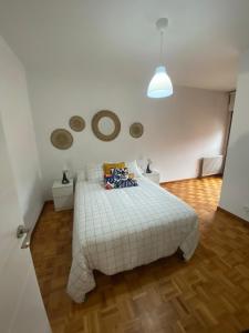 a bedroom with a white bed and a wooden floor at Céntrico, amplio y bonito apartamento en Cambados in Cambados