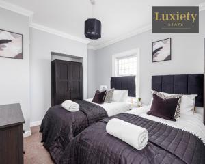 two beds in a room with white walls at Modern house - City Centre - Contractors Hub, Families, Free Parking by Luxiety Stays in Southend-on-Sea
