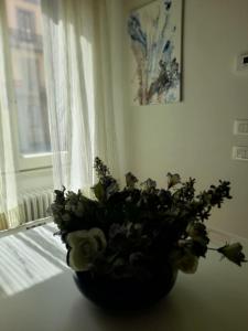 eine Blumenvase, die auf einem Tisch neben einem Fenster sitzt in der Unterkunft Il nido di Aurora centro Firenze in Florenz
