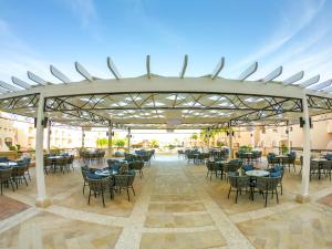 un patio avec des tables et des chaises sous un pavillon dans l'établissement Ivy Cyrene Sharm Resort Adults Friendly Plus 13, à Charm el-Cheikh