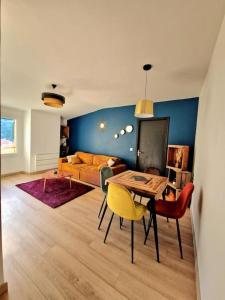 a living room with a table and chairs and a couch at Appartement l'Insolite in Vernet-les-Bains