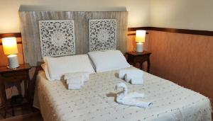 a bedroom with a white bed with two lamps at Hotel San Felice in Bologna