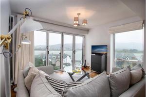 ein Wohnzimmer mit Sofa und Tisch in der Unterkunft Deganwy Tower Apartment in Deganwy