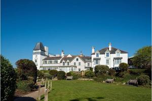 ein großes weißes Haus mit einem Rasen davor in der Unterkunft Deganwy Tower Apartment in Deganwy