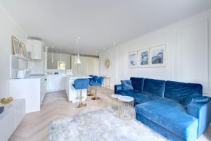 sala de estar con sofá azul y cocina en DR Apartments - Mavik, en Sopot