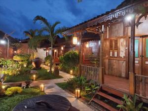 une maison avec un jardin éclairé la nuit dans l'établissement Wisma Andany, à Jepara