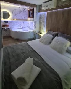 um quarto com uma cama e uma banheira com uma toalha em Apartamentos Los Robles em Alcalá del Júcar