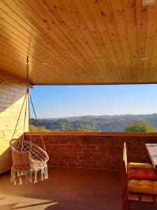una veranda con amaca appesa a un soffitto in legno di Kućica na brijegu a Selnica