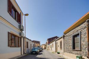 eine Straße mit Autos, die an der Seite eines Gebäudes geparkt sind in der Unterkunft La Casa delle Zie - Cabras in Càbras