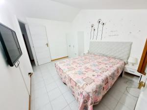 1 dormitorio con 1 cama y TV. en Trilocale in affitto, en Marzocca di Senigallia