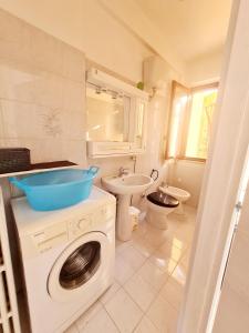 y baño con lavadora y lavamanos. en Trilocale in affitto, en Marzocca di Senigallia