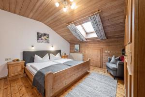 1 dormitorio con 1 cama y 1 silla en una habitación en Ferienwohnung Schustererhof, en Stumm