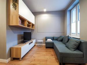 ein Wohnzimmer mit einem Sofa und einem TV in der Unterkunft Stara Drukarnia - Apartamenty typu Studio in Bydgoszcz