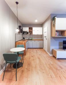 uma cozinha e sala de estar com mesa e cadeiras em Stara Drukarnia - Apartamenty typu Studio em Bydgoszcz