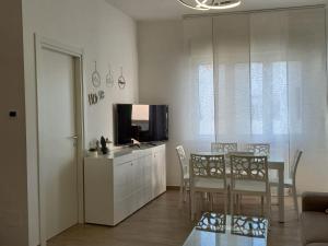 a living room with a dining table and a television at VerdeMare in Montesilvano