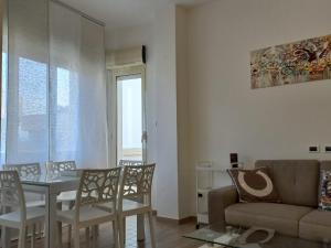 a living room with a couch and a table and chairs at VerdeMare in Montesilvano