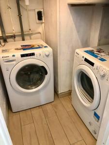 a washing machine and a washer in a laundry room at Chez F&K in Elbeuf