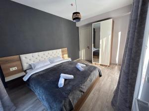 une chambre avec un grand lit avec deux serviettes dessus dans l'établissement Bakuriani Hotel Apartments 301, à Bakuriani