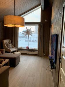 una sala de estar con una gran ventana con vistas al océano en Beautiful cabin close to activities in Trysil, Trysilfjellet, with Sauna, 4 Bedrooms, 2 bathrooms and Wifi, en Trysil