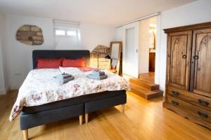 a bedroom with a large bed and a wooden dresser at Romantische Ferienwohnung in Jugendstilvilla - Villa del Viento in Neustadt an der Weinstraße