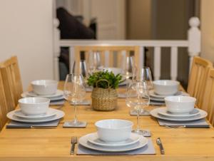 un tavolo in legno con piatti e bicchieri da vino sopra di Relaxing Retreat Perfect For Longer Stays a Southampton