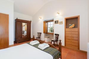- une chambre avec un lit, une commode et des chaises dans l'établissement Casa de S. Paio - 3 bedroom villa w/ pool & garden, à Braga 17 autres photos