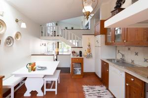 une cuisine avec une table blanche et un escalier dans l'établissement Casa de S. Paio - 3 bedroom villa w/ pool & garden, à Braga