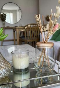 una mesa de cristal con una vela y un jarrón. en Reconquista Temporarios en Reconquista