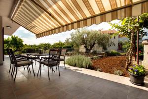 a patio with a table and chairs under awning at Apartment in Rovinj/Istrien 11487 in Štanga
