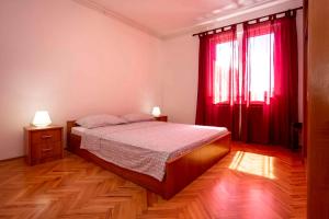 a bedroom with a bed and a window with red curtains at Apartment in Rovinj/Istrien 11487 in Štanga