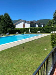 a swimming pool in a yard next to a fence at Appartamento feriolo Margherita in Baveno