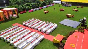 una vista aérea de un césped con sillas y mesas blancas en Hotel Shree en Indore