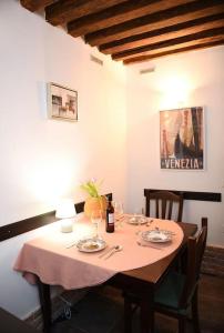 Grace Apartment in Venice في البندقية: طاولة طعام عليها قطعة قماش وردية