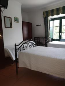 a bedroom with two beds and a window at Hotel Santa Comba in Moura