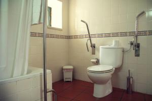 a bathroom with a toilet and a shower and a tub at Hotel Santa Comba in Moura