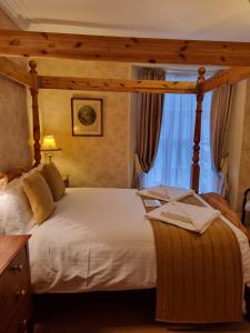 ein Schlafzimmer mit einem großen weißen Bett in einem Zimmer in der Unterkunft St Vincent Guest House in Lynton