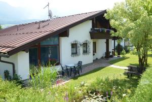 ein Cottage mit einem Tisch und Stühlen im Hof in der Unterkunft Ferienwohnung Gästehaus Am Buchenbichl in Schönau am Königssee