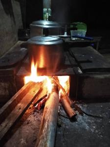 una olla en una estufa con fuego en Quitinete aconchegante em Sobradinho, São Tomé das Letras, en São Thomé das Letras