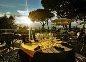 een tafel met glazen erop met zonsondergang bij Hotel Ermitage in Saint-Tropez