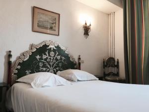 a bedroom with a white bed with a black and white headboard at Hôtel des Templiers in Collioure