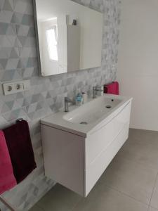 Un baño con un lavabo blanco y un espejo. en Ático Primera Línea Parque de Elche, en Benidorm 15 fotos más