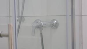 a shower with a shower head in a bathroom at Evsenn Hotel in Reutlingen