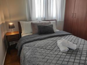 - une chambre dotée d'un lit avec deux chaussures blanches dans l'établissement Kashmir Luxury Apartments, à Neos Marmaras