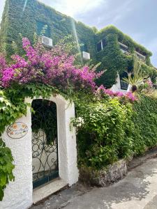 ein Gebäude mit einem Tor mit lila Blumen darauf in der Unterkunft Casa Malo' in Ischia